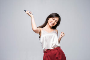 Winning success woman happy ecstatic celebrating being a winner. Dynamic energetic image of multiracial Caucasian Asian female model isolated on white background waist up.