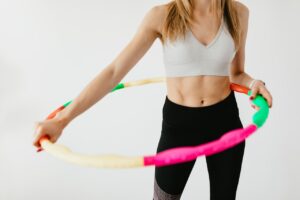 Photo by Karolina Grabowska: https://www.pexels.com/photo/crop-sportswoman-exercising-with-gymnastic-hula-hoop-4498154/